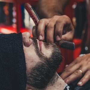 Barber shaving a mans beard