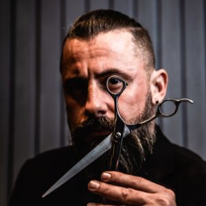 A Bearded Man Holding a Scissors